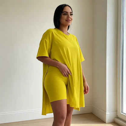 Dwuczęściowy letni komplet dla kobiet plus size, składający się z długiego topu (z rozcięciem z boku) i szortów, wykonany z miękkiego, elastycznego i przewiewnego materiału.
